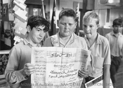 Students from the Oxley High School, Tamworth, NSW, examine a copy of the Malaysian newspaper "Utusan Melayu"